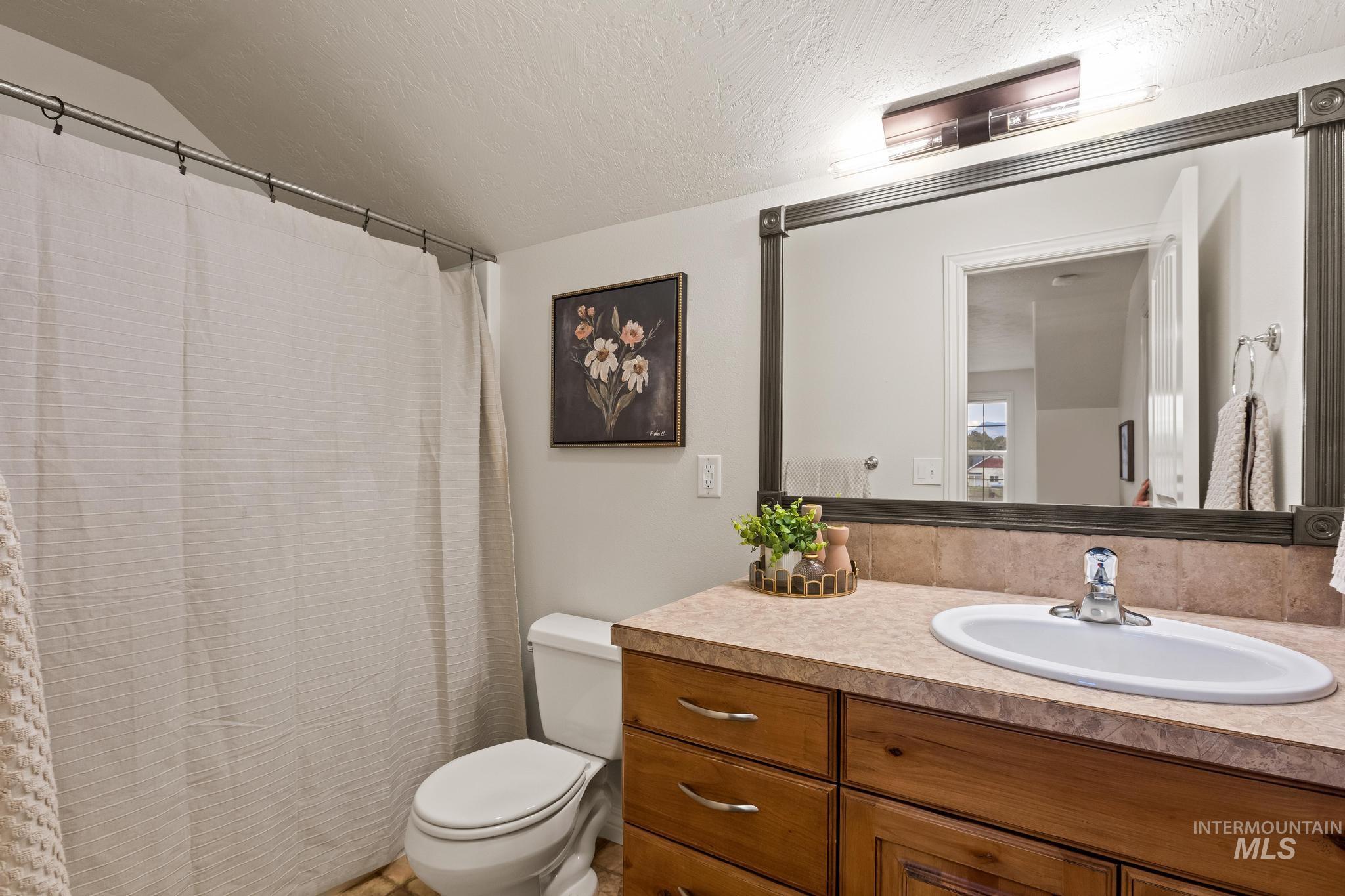2185 Waterwheel Road Emmett, ID 83617 - Photo 18 of 49 Bathroom with vanity, a shower with curtain, a textured ceiling, and lofted ceiling