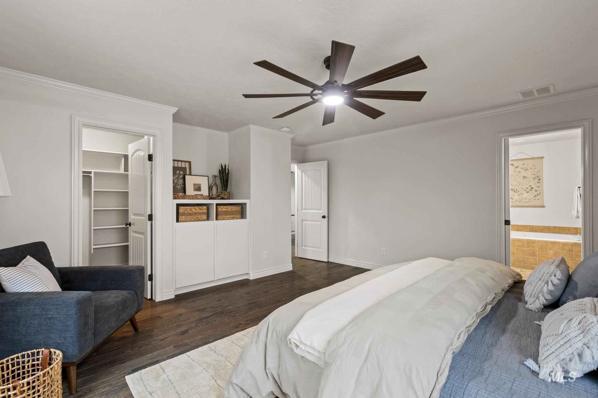 2185 Waterwheel Road Emmett, ID 83617 - Photo 21 of 49 Bedroom featuring a walk in closet, ornamental molding, wood finished floors, connected bathroom, and a ceiling fan