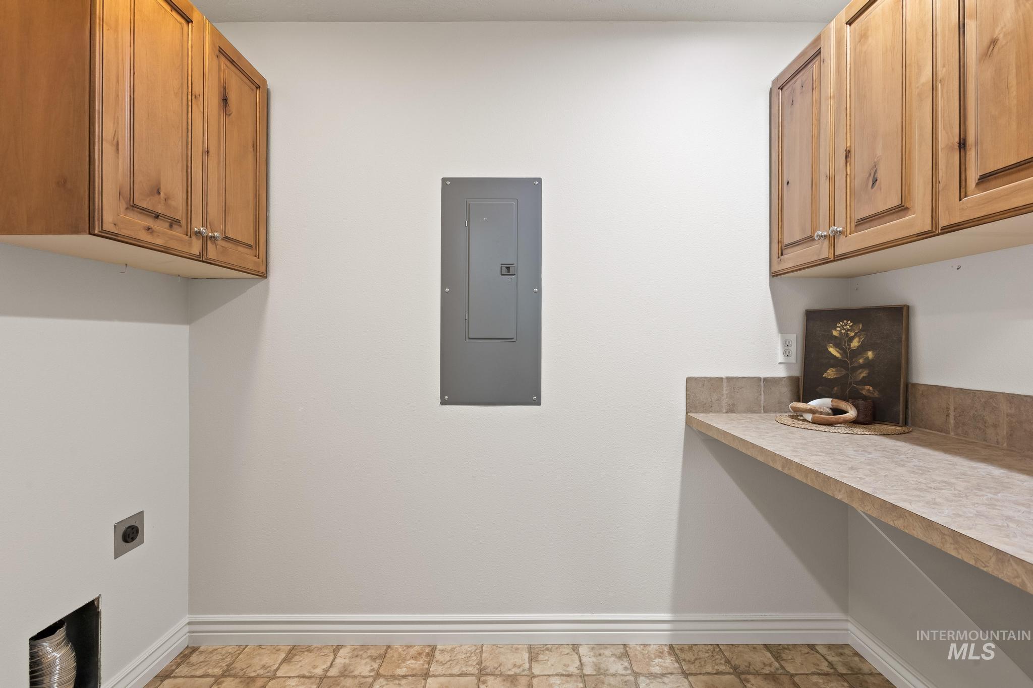 2185 Waterwheel Road Emmett, ID 83617 - Photo 39 of 49 Laundry room featuring electric panel, cabinet space, electric dryer hookup, and stone finish floors