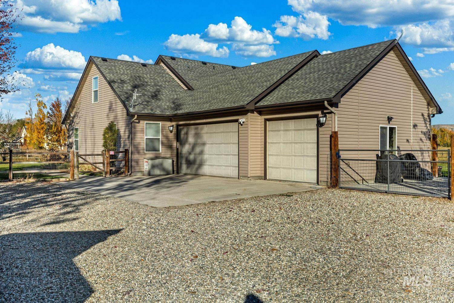 2185 Waterwheel Road Emmett, ID 83617 - Photo 43 of 49 View of home's exterior with a gate, a shingled roof, driveway, and an attached garage