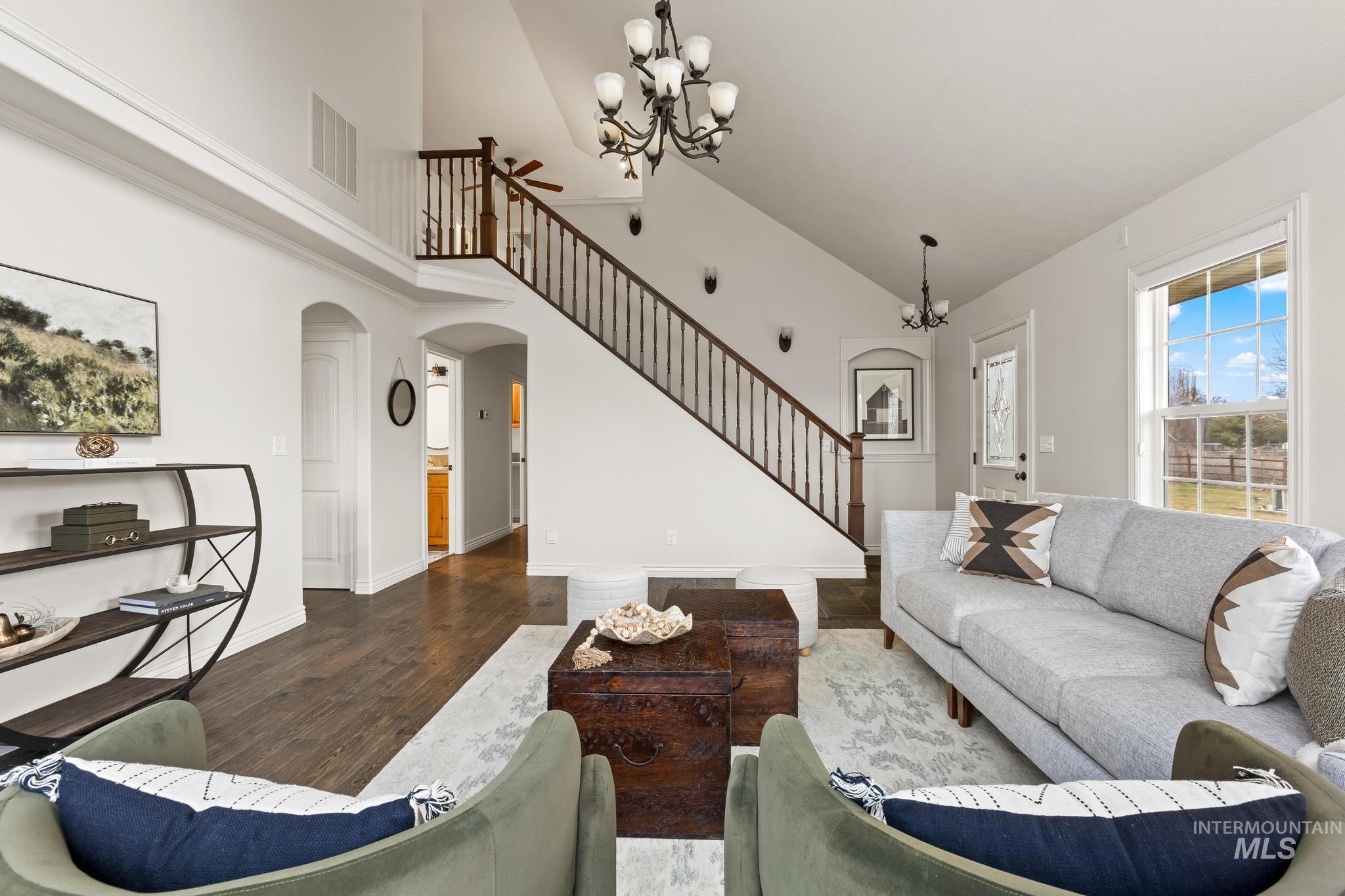 2185 Waterwheel Road Emmett, ID 83617 - Photo 6 of 49 Living room with a chandelier, wood finished floors, arched walkways, stairway, and high vaulted ceiling