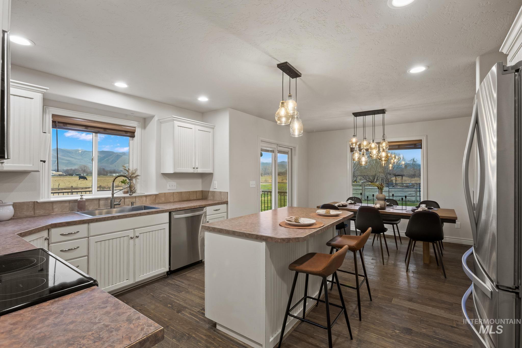 2185 Waterwheel Road Emmett, ID 83617 - Photo 8 of 49 Kitchen with a center island, stainless steel appliances, white cabinets, hanging light fixtures, and recessed lighting