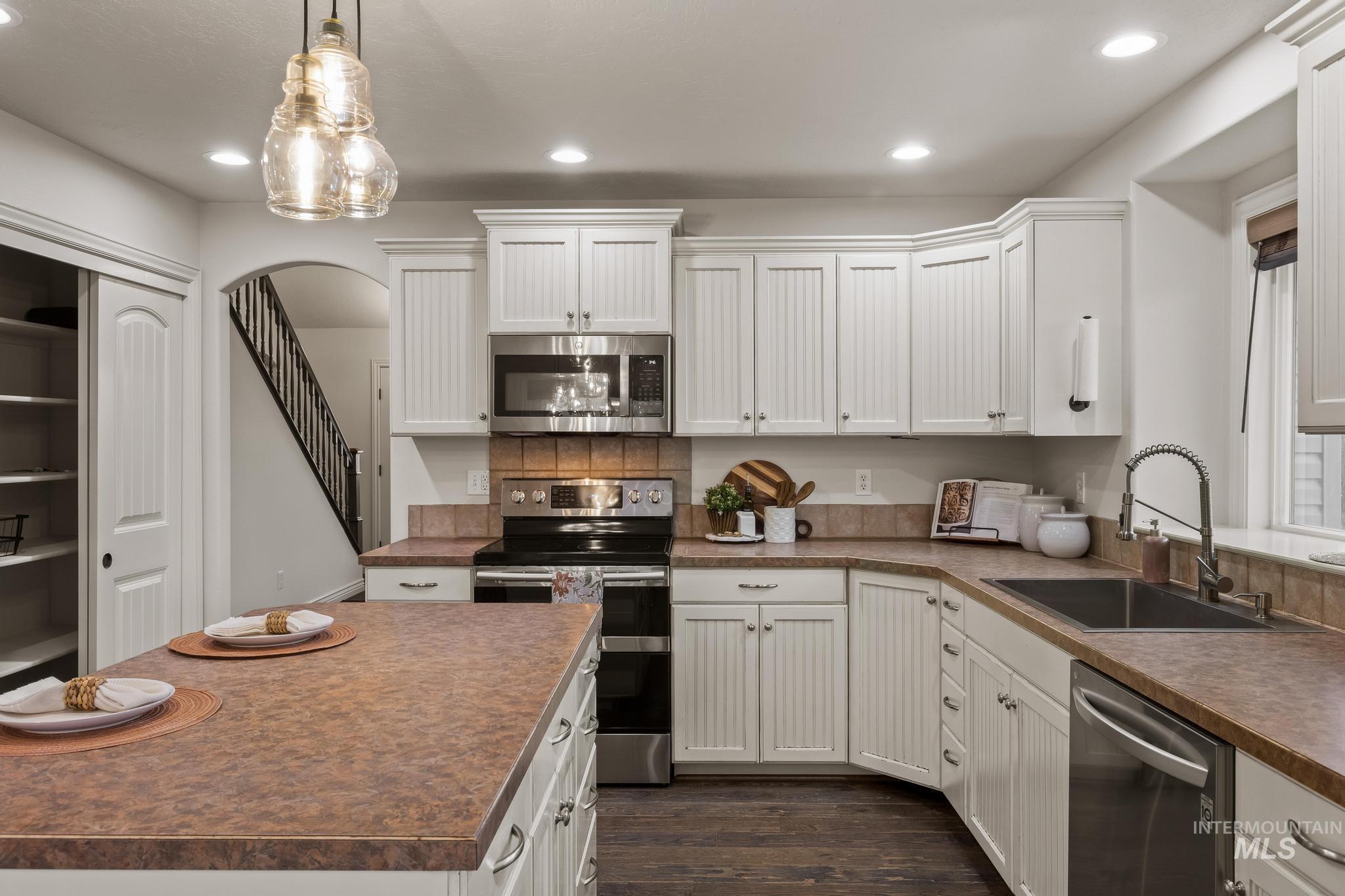 2185 Waterwheel Road Emmett, ID 83617 - Photo 9 of 49 Kitchen featuring stainless steel appliances, white cabinets, arched walkways, dark wood finished floors, and recessed lighting
