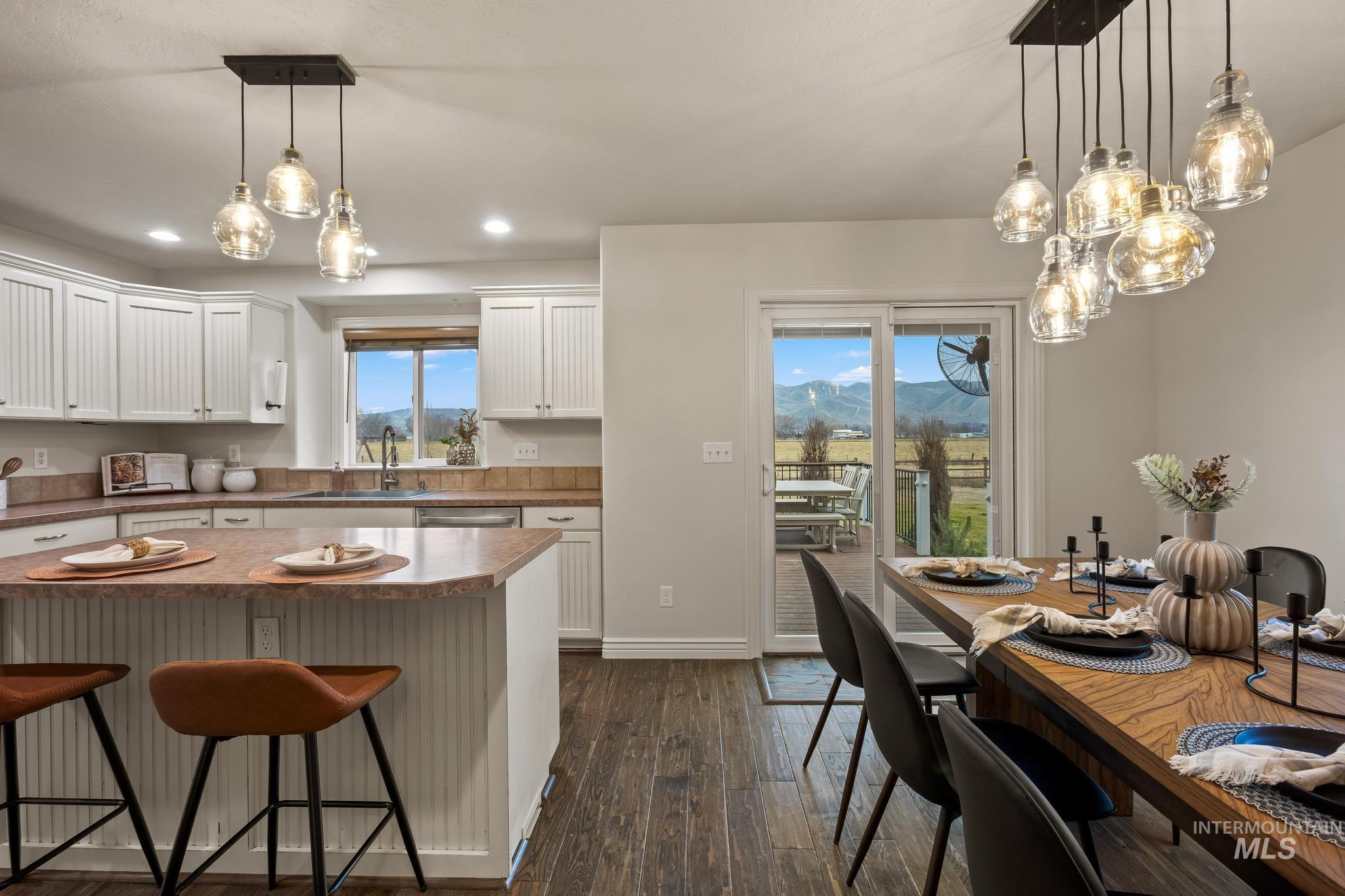 2185 Waterwheel Road Emmett, ID 83617 - Photo 10 of 49 Kitchen featuring a breakfast bar area, white cabinets, pendant lighting, dark wood-style floors, and recessed lighting