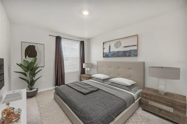a bedroom with a large bed and a potted plant