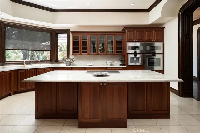a view of a hallway with wooden floor a fireplace and a chandelier