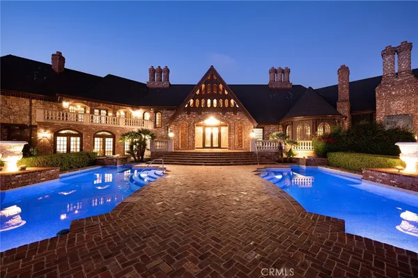 a view of a swimming pool with lawn chairs under an umbrella