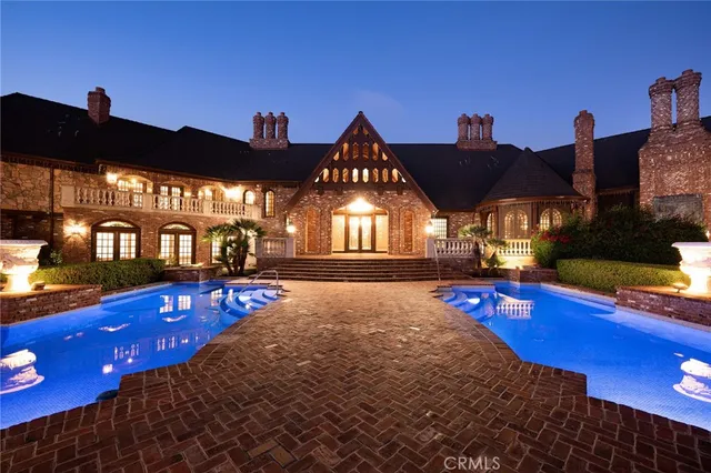 a view of a swimming pool with lawn chairs under an umbrella
