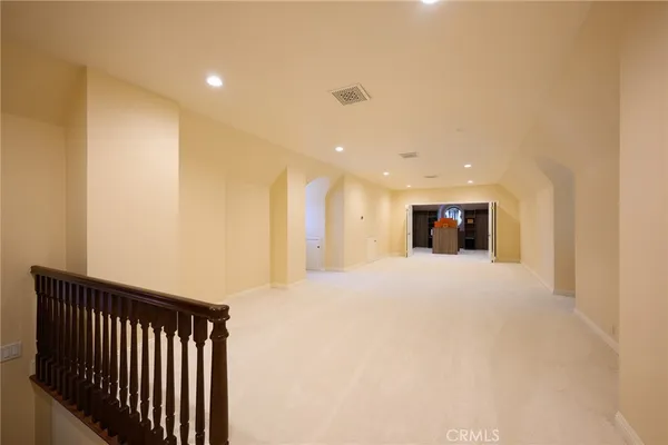 a view of a room with wooden floor and a chandelier