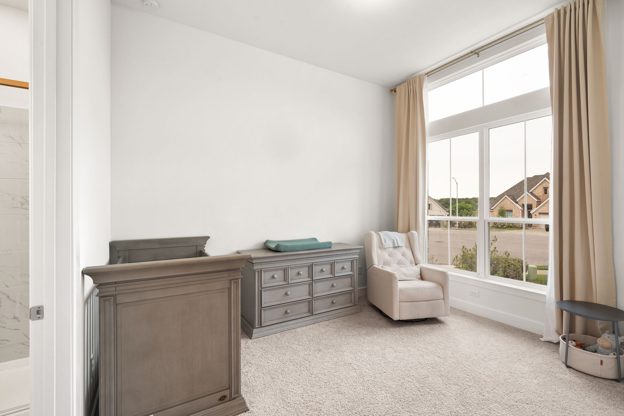 515 Watershield Cove Georgetown, TX 78633 - Photo 7 of 40 A well-lit bedroom features plush carpeting and a soaring window overlooking the neighborhood.