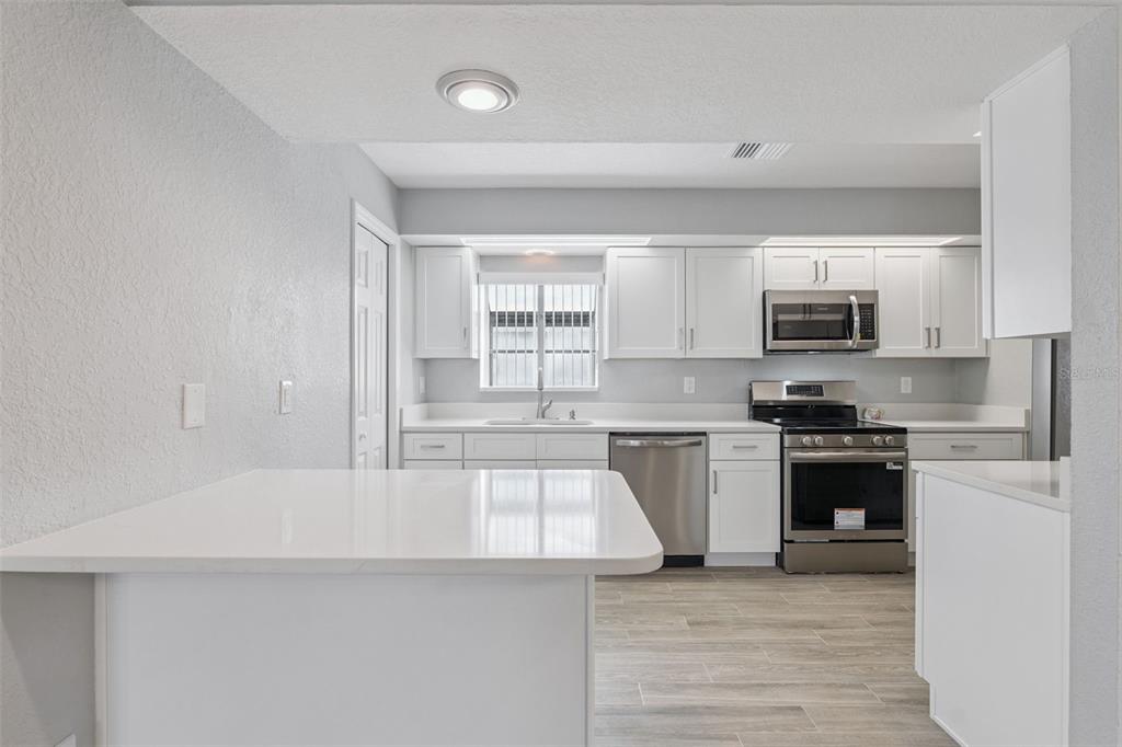 1932 Maple Circle, Unit 1932 Tavares, FL 32778 - Photo 11 of 39 a kitchen with granite countertop white cabinets and stainless steel appliances