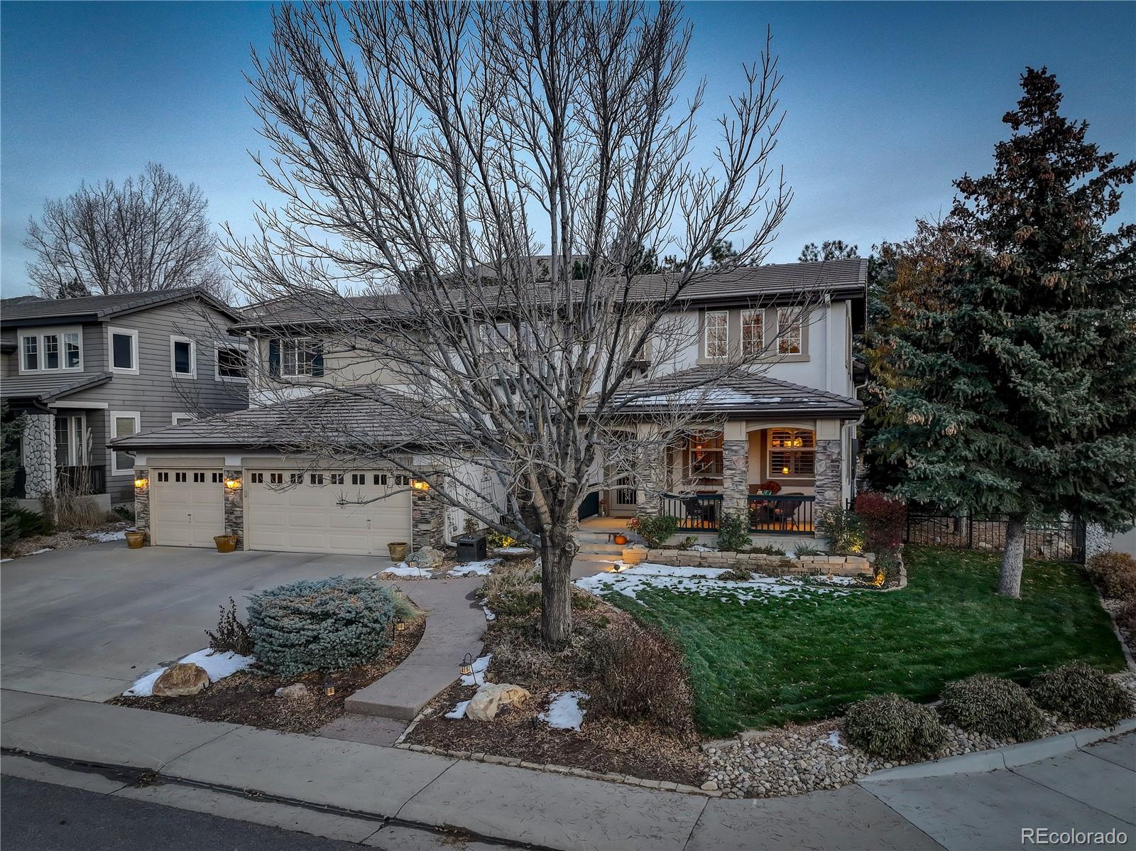 a front view of a house with garden and trees