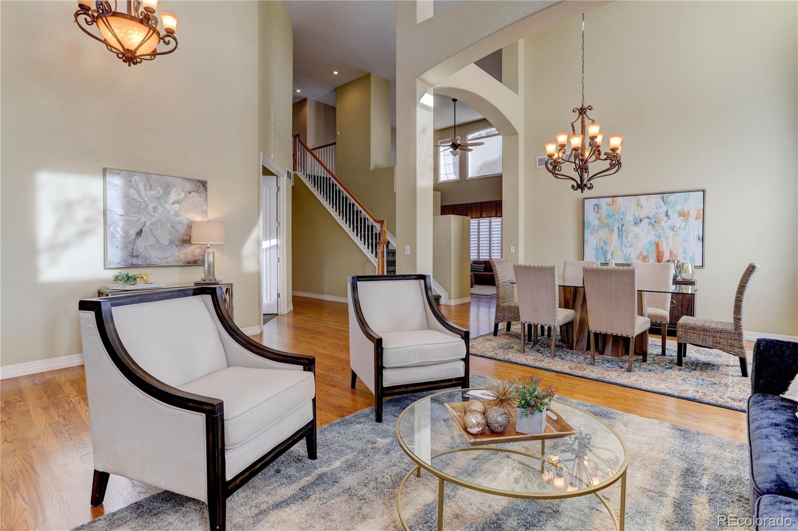 2720 Rockbridge Way Highlands Ranch, CO 80129 - Photo 11 of 39 a living room with furniture a dining table and a chandelier