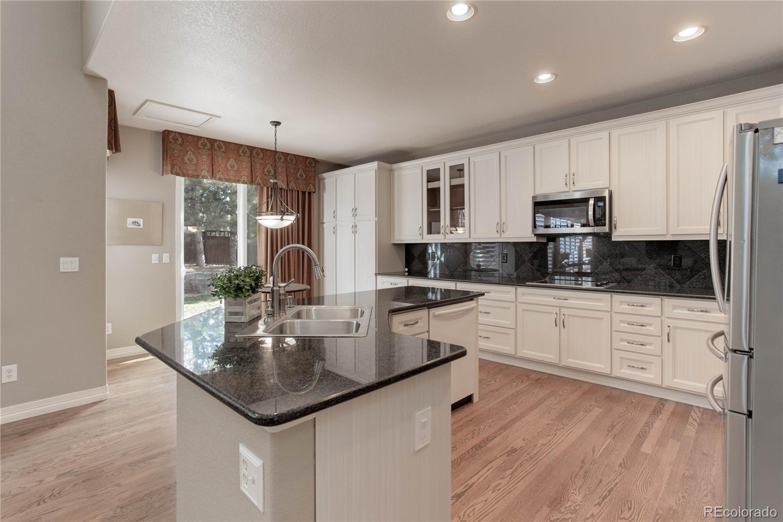 2720 Rockbridge Way Highlands Ranch, CO 80129 - Photo 13 of 39 a kitchen with stainless steel appliances granite countertop a sink a stove and microwave