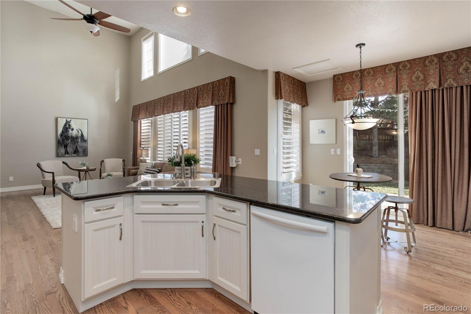 2720 Rockbridge Way Highlands Ranch, CO 80129 - Photo 15 of 39 a kitchen with granite countertop a sink cabinets and stainless steel appliances