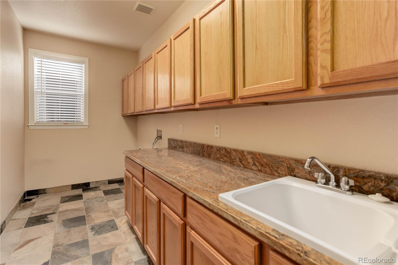 2720 Rockbridge Way Highlands Ranch, CO 80129 - Photo 24 of 39 a kitchen with a sink and cabinets