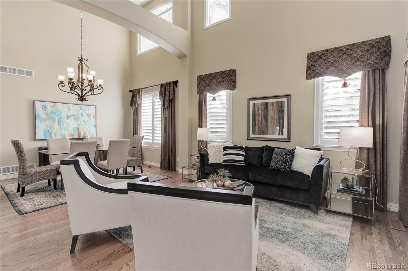2720 Rockbridge Way Highlands Ranch, CO 80129 - Photo 9 of 39 a living room with furniture a chandelier and a window