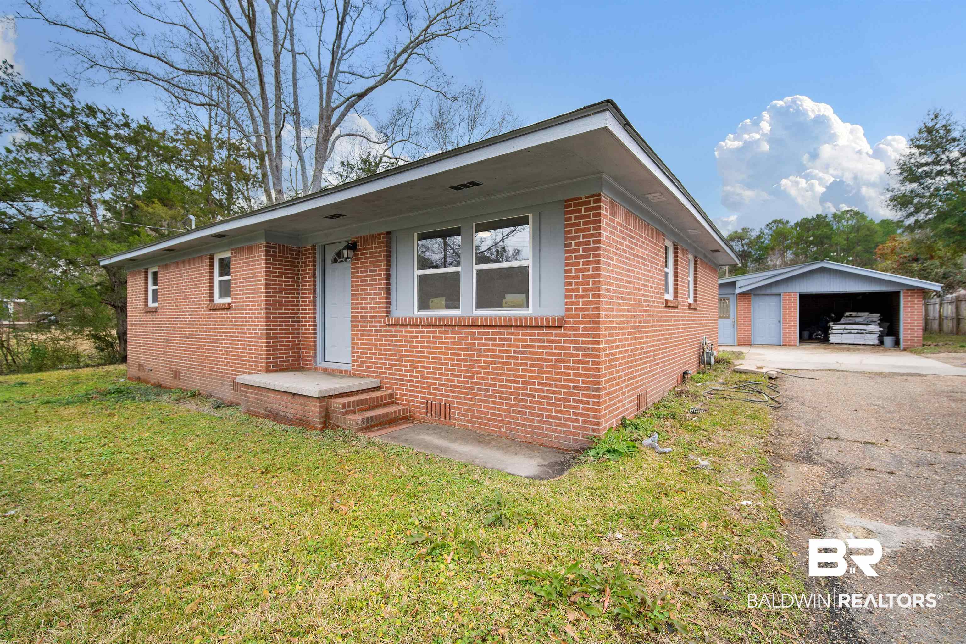 2119 Autrey Avenue Eight Mile, AL 36613 - Photo 3 of 22 View of front of property featuring a garage, an outdoor structure, and a front lawn