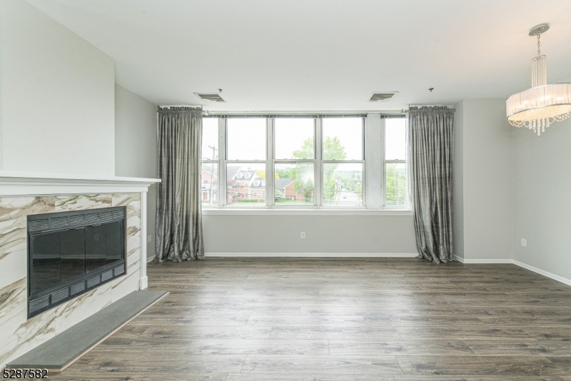 240 Main Street, Unit 313 Little Falls, NJ 07424 - Photo 1 of 21 a view of an empty room with wooden floor and a window