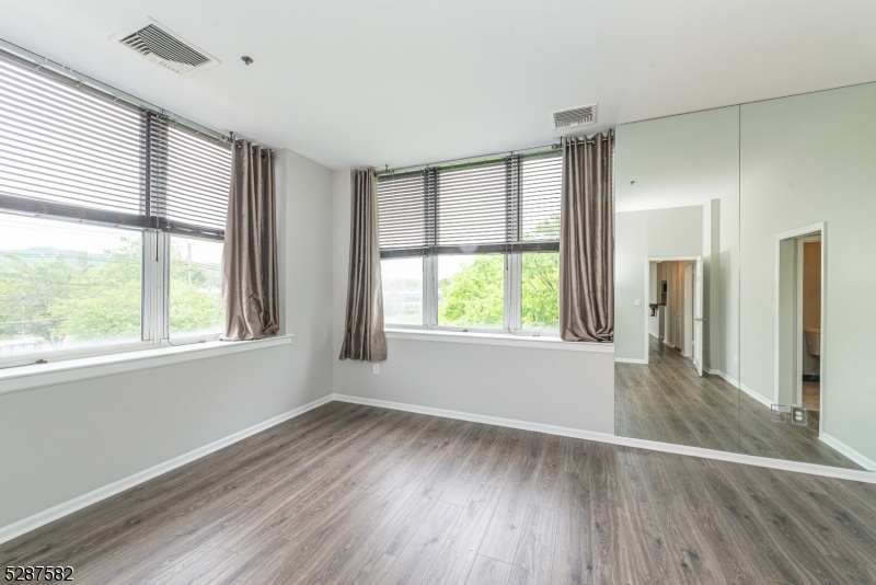 240 Main Street, Unit 313 Little Falls, NJ 07424 - Photo 9 of 21 a view of an empty room with wooden floor and a window