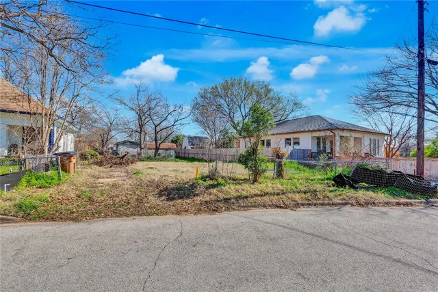 a front view of a house with a yard and potted plants