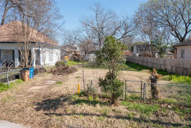a backyard of a house with large trees and outdoor seating