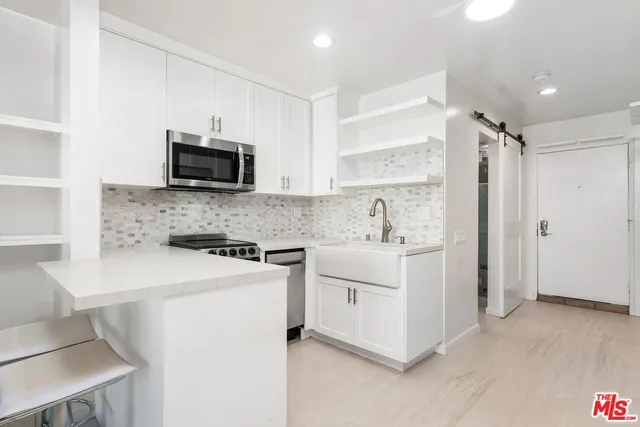 a room with a refrigerator and cabinets