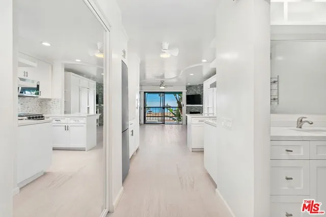 a kitchen with white cabinets and appliances