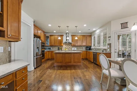 a kitchen with a refrigerator and wooden floor