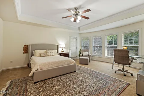 a bedroom with a bed a chair and a chandelier