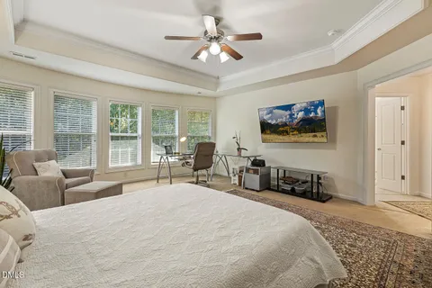 a bedroom with a bed a couch and a large window with the outer view