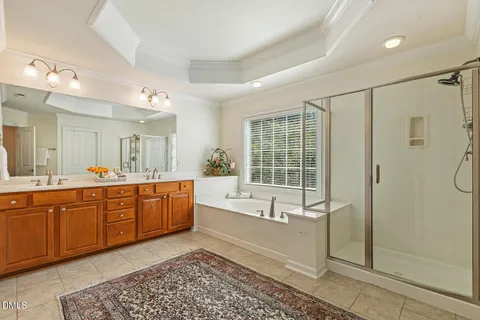 a spacious bathroom with a tub sink shower and mirror