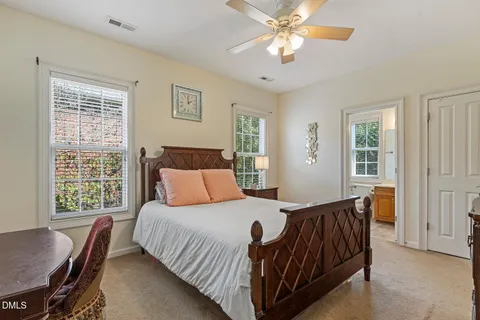 a bedroom with a large bed a chandelier and a window