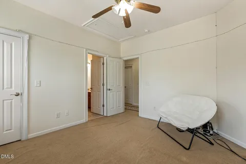 a view of an empty room with a chandelier fan