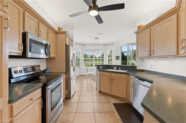 a kitchen with stainless steel appliances granite countertop a refrigerator a stove top oven a sink and dishwasher