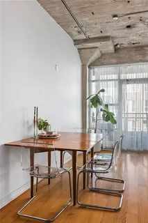 a kitchen with stainless steel appliances granite countertop a stove refrigerator a dining table and chairs with wooden floor