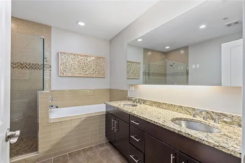 a bathroom with a granite countertop sink and a bathtub