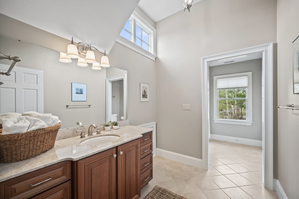 30 Nobscot Road, Unit 1 Sudbury, MA 01776 - Photo 38 of 42 a spacious bathroom with a granite countertop sink a mirror and a vanity