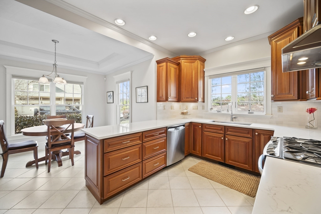 30 Nobscot Road, Unit 1 Sudbury, MA 01776 - Photo 9 of 42 a kitchen with stainless steel appliances granite countertop wooden cabinets a sink a stove a dining table and chairs