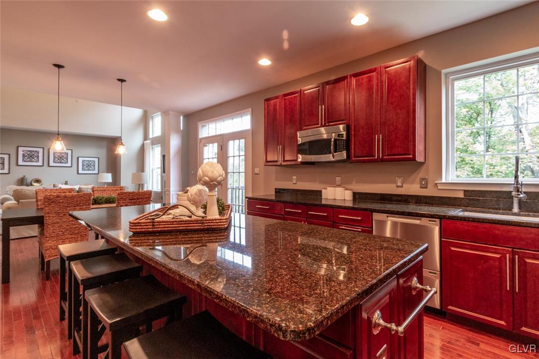 3153 Olympic Drive Emmaus, PA 18049 - Photo 19 of 40 a kitchen with a stove a sink a microwave a dining table and chairs