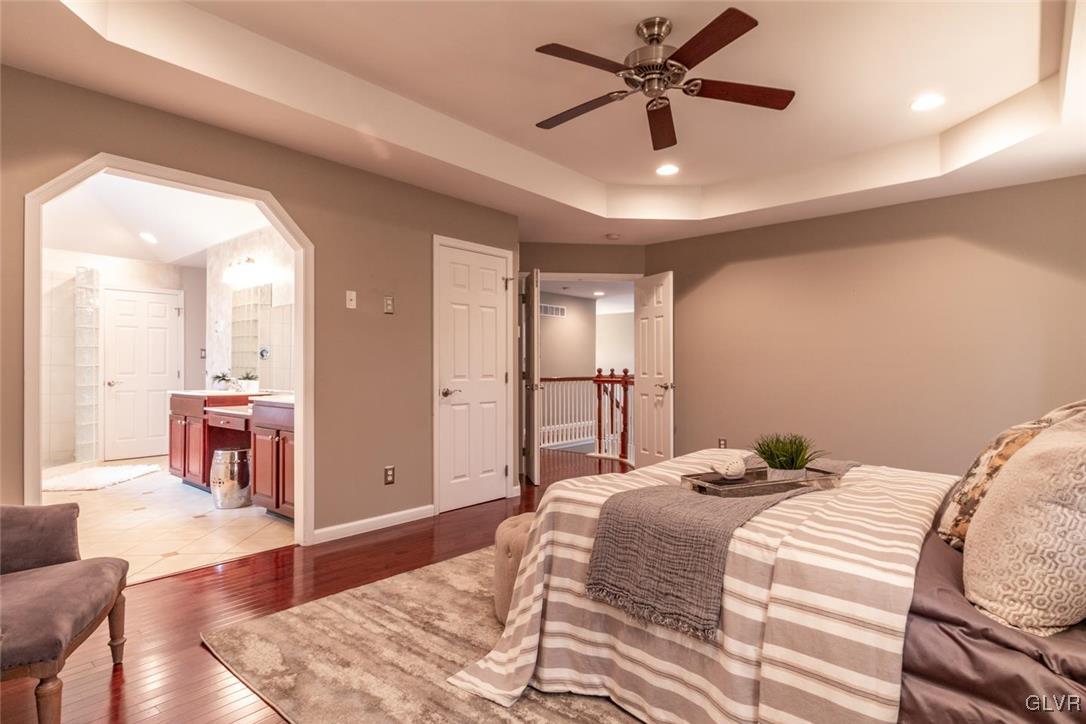 3153 Olympic Drive Emmaus, PA 18049 - Photo 33 of 40 a bedroom with a large bed a chandelier and a rug