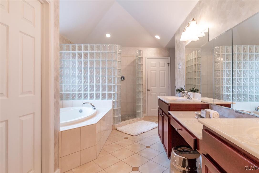 3153 Olympic Drive Emmaus, PA 18049 - Photo 34 of 40 a bathroom with a double vanity sink a mirror and a bathtub