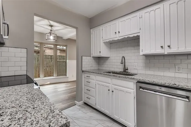 a kitchen with granite countertop a sink stainless steel appliances and cabinets