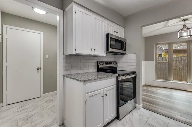 a kitchen with stainless steel appliances granite countertop a stove a sink and a microwave