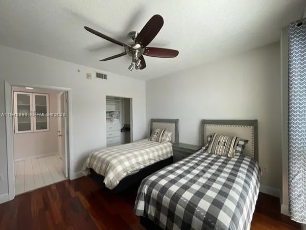 a bedroom with two beds and wooden floor