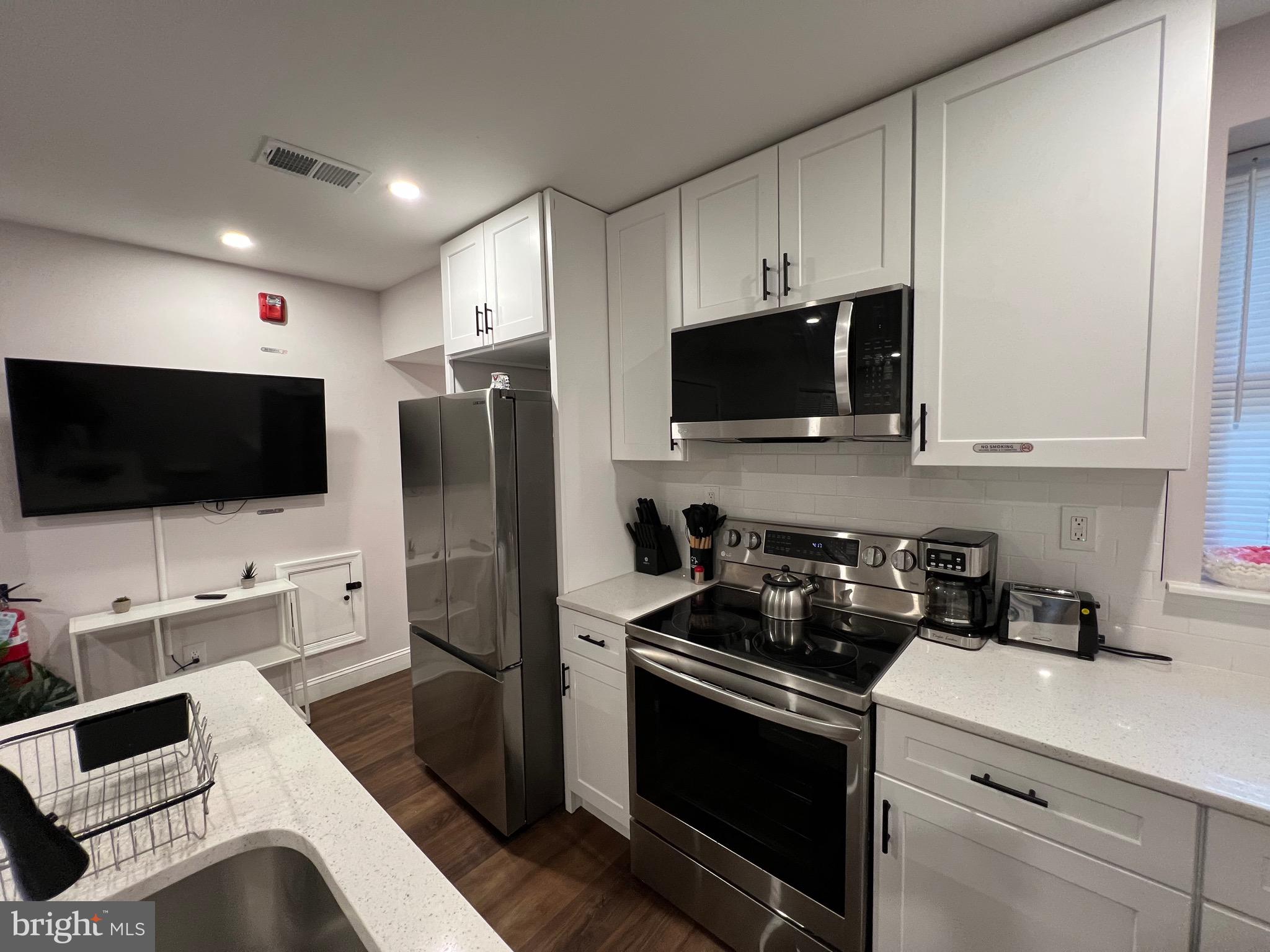 1985 North 63rd Street, Unit 2 Philadelphia, PA 19151 - Photo 6 of 23 a kitchen with stainless steel appliances a stove microwave and refrigerator