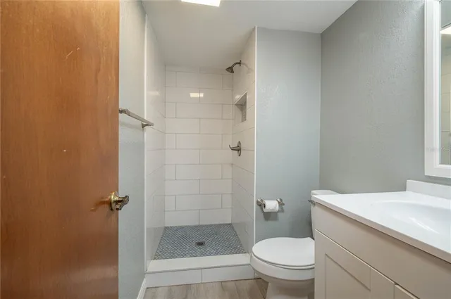 a bathroom with a granite countertop toilet a sink and shower