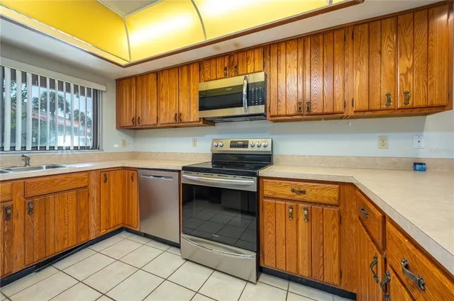 a kitchen with stainless steel appliances granite countertop wooden cabinets a stove top oven a sink and dishwasher