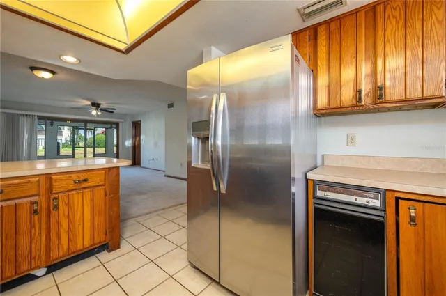 a kitchen with stainless steel appliances granite countertop a refrigerator a oven and a sink with granite countertops