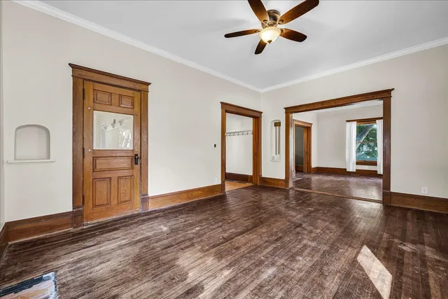 a view of an empty room with window and wooden floor